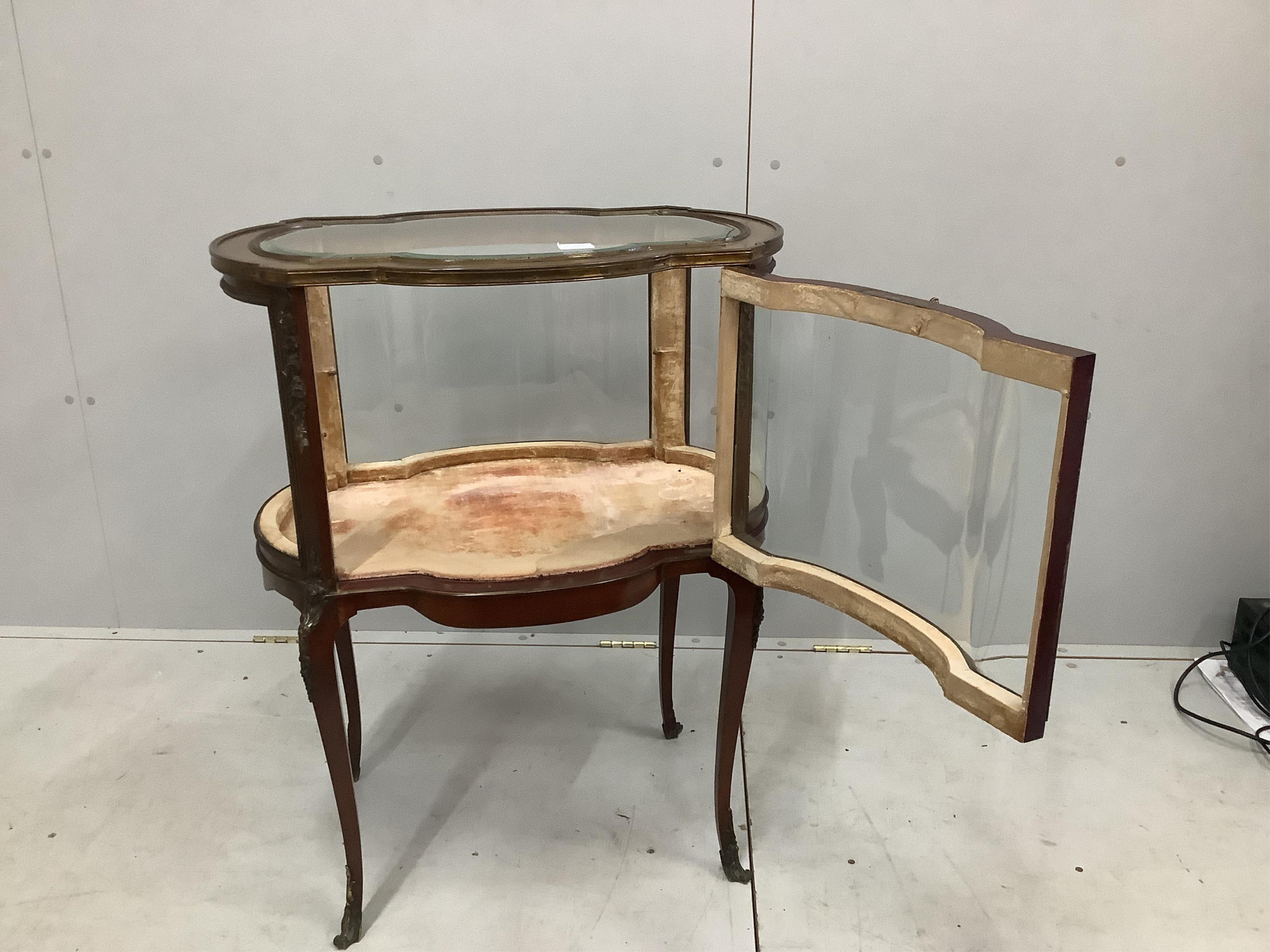 An early 20th century gilt metal mounted mahogany bijouterie cabinet, (one glass panel missing), width 68cm, depth 46cm, height 86cm. Condition - fair